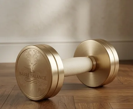 Goldene Hantel mit Barre-Balance-Prägung auf dem Parkett